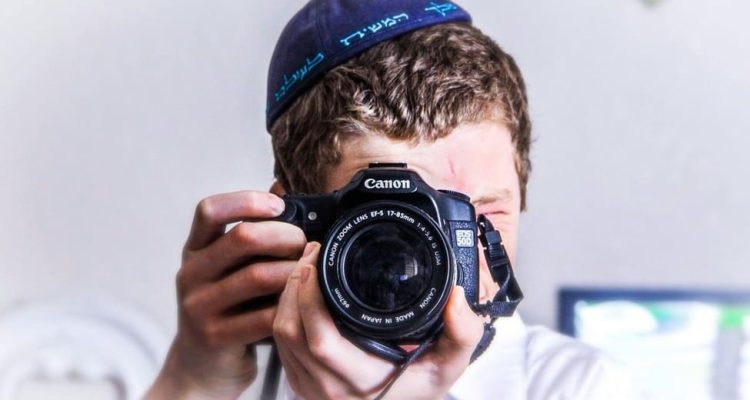 A boy clicking a picture with a camera