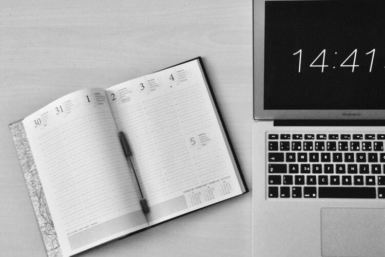 Flat Lay Photography of Unfold Book Beside Macbook