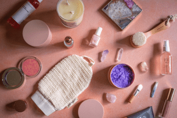 Variety of cosmetics on pink table for beauty bloggers