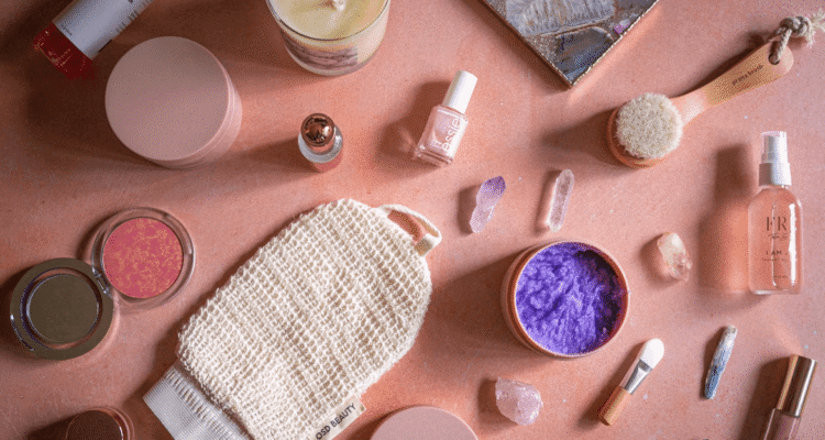 Variety of cosmetics on pink table for beauty bloggers