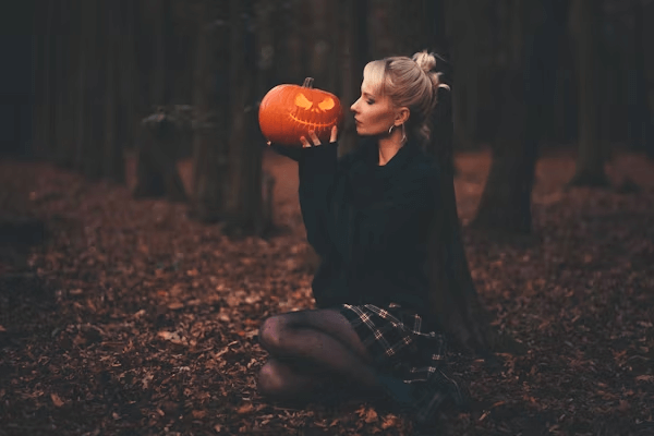Woman holding a pumpkin wearing halloween costume