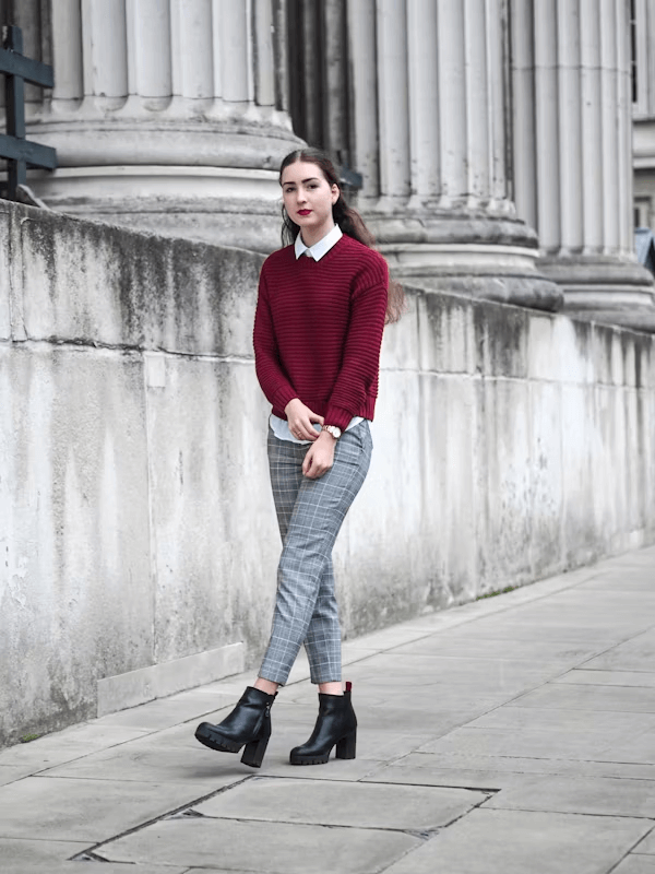 Woman in red sweater and plaid pants with London fashion style