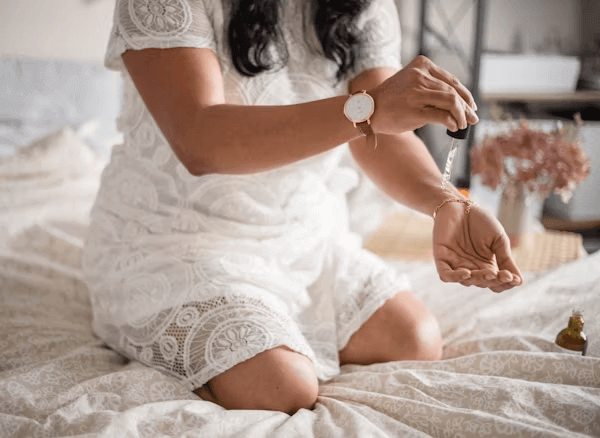 Woman in white dress sitting on bed related to hyperpigmentation discussion