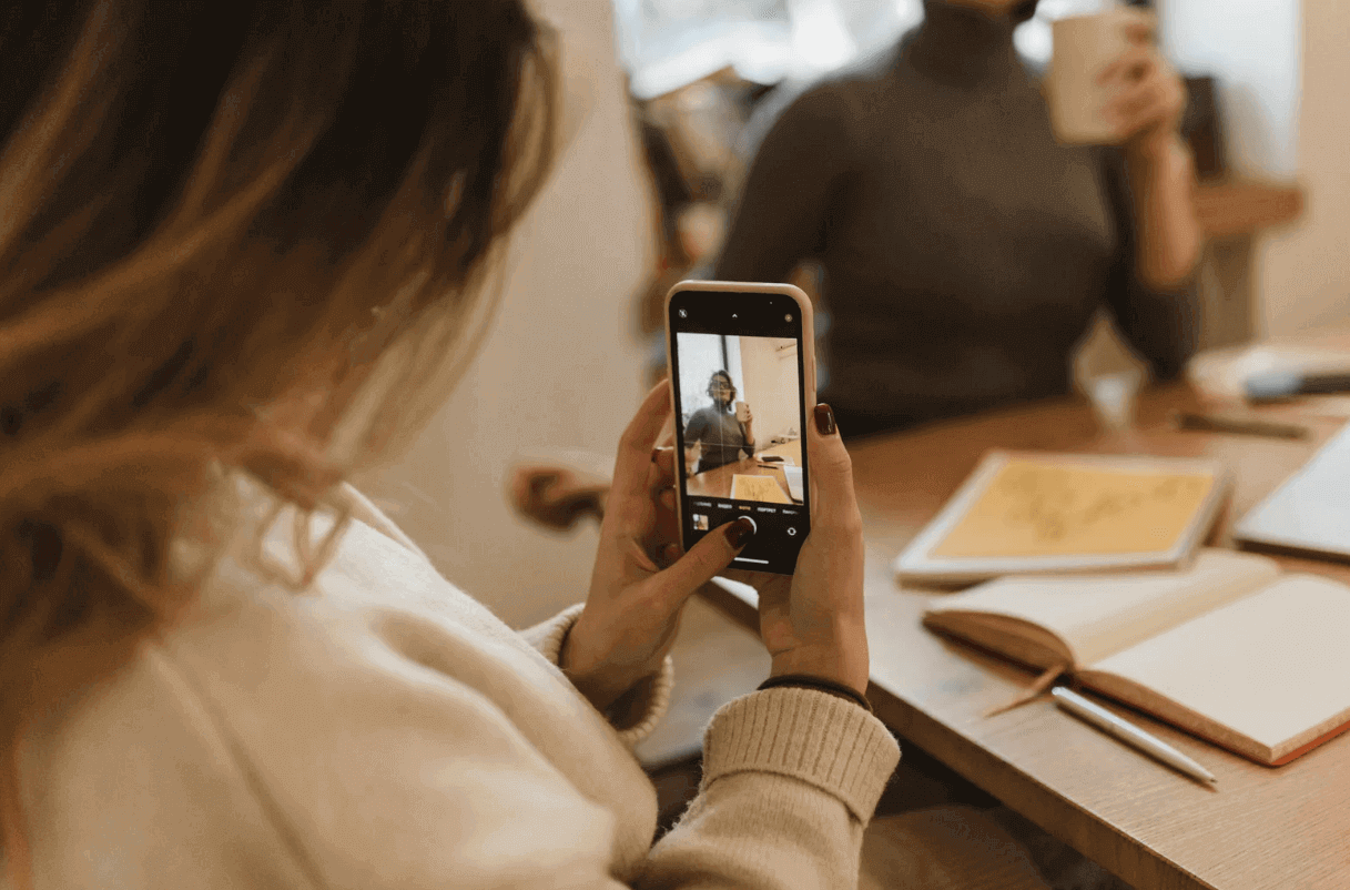 Woman taking photo with phone, showcasing trendy clear iPhone case