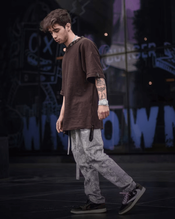 Young man in brown shirt on stage showcasing streetwear